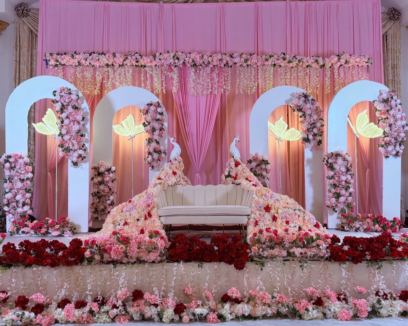 Half Saree Ceremony Stage with Floral Arches and Peacocks